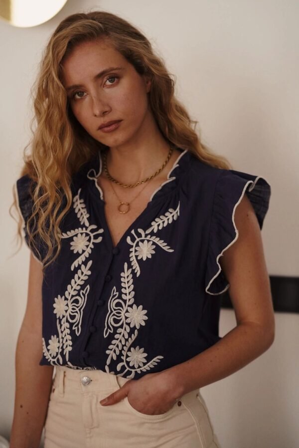Blusa sin mangas con bordado marino y beige detalle Blusa sin mangas marino con bordados en relieve
